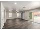Spacious living room with tile floors, sliding glass door to patio, ceiling fan, and barn doors at 6637 W Watkins St, Phoenix, AZ 85043