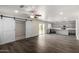 Spacious living room featuring wood floors, modern gray cabinets and sliding barn doors at 6637 W Watkins St, Phoenix, AZ 85043