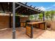Outdoor kitchen and dining area featuring custom cabinetry, modern appliances, and a built-in barbecue at 6637 W Watkins St, Phoenix, AZ 85043