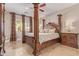 Main bedroom suite featuring a luxurious four-poster bed, stylish furnishings, and natural light at 6847 S 27Th Pl, Phoenix, AZ 85042
