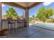 Outdoor bar area with seating overlooks the sparkling pool and lush landscaping, creating an ideal relaxation space at 6847 S 27Th Pl, Phoenix, AZ 85042