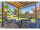 Inviting covered patio with lounge seating and a putting green in the landscaped backyard at 6847 S 27Th Pl, Phoenix, AZ 85042