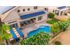 Aerial view of a backyard featuring a pool, covered patio, and solar panels at 6971 W El Cortez Pl, Peoria, AZ 85383