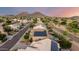 Expansive aerial view of a community, featuring maintained landscaping, nearby mountains, and sidewalks at 6971 W El Cortez Pl, Peoria, AZ 85383