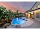 Stunning backyard features a sparkling pool, covered patio, lounge area, and lush landscaping at 6971 W El Cortez Pl, Peoria, AZ 85383