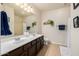 Bright bathroom with double sink vanity, large mirror and walk-in shower at 6971 W El Cortez Pl, Peoria, AZ 85383