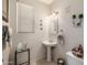 Traditional powder room featuring a pedestal sink, neutral tones, and decorative wall accents at 6971 W El Cortez Pl, Peoria, AZ 85383