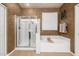 Bright bathroom featuring a glass-enclosed shower, soaking tub, and neutral tones for a relaxing experience at 6971 W El Cortez Pl, Peoria, AZ 85383