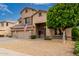 Two story single Gathering home featuring a low maintenance gravel front yard, three car garage, and covered porch at 6971 W El Cortez Pl, Peoria, AZ 85383