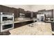 Granite counters, stainless appliances, and tile backsplash in the kitchen at 6971 W El Cortez Pl, Peoria, AZ 85383