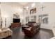 Spacious living room with hardwood floors, a ceiling fan, leather furniture, and an entertainment center at 6971 W El Cortez Pl, Peoria, AZ 85383