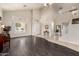 Spacious living room with high ceilings, large windows, and a seamless flow between the tile and wood flooring at 6971 W El Cortez Pl, Peoria, AZ 85383