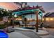 Cozy outdoor lounge area with a pergola, string lights, and a basketball hoop at 6971 W El Cortez Pl, Peoria, AZ 85383