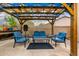 Cozy outdoor pergola lounge area with stylish blue seating, perfect for relaxing and entertaining in a serene setting at 6971 W El Cortez Pl, Peoria, AZ 85383