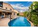 Relaxing backyard pool features a basketball hoop, rock waterfall, and mature landscaping at 6971 W El Cortez Pl, Peoria, AZ 85383