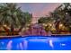 A close-up of a backyard pool showcasing the rock waterfall feature and ambient lighting at 6971 W El Cortez Pl, Peoria, AZ 85383