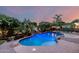 An outdoor pool with waterfall, basketball hoop, string lights, and a covered lounge area for relaxation at 6971 W El Cortez Pl, Peoria, AZ 85383