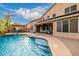 Stunning backyard pool with rock accents and lush landscaping with an outdoor seating area for relaxation and entertaining at 6971 W El Cortez Pl, Peoria, AZ 85383