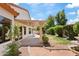 A charming backyard with a covered patio, vibrant flowers, and a serene water feature at 732 W Sagebrush St, Gilbert, AZ 85233