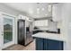 Well lit kitchen featuring stainless steel appliances, white cabinets, blue cabinets and glass door to the backyard at 738 S Pomeroy --, Mesa, AZ 85210