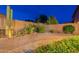 Desert landscaped backyard features decorative cacti and gravel ground cover, bordered by a charming brick pathway at 7606 E Globemallow Ln, Gold Canyon, AZ 85118