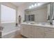 Bright bathroom with double vanity, large mirror, soaking tub, and tile flooring at 7606 E Globemallow Ln, Gold Canyon, AZ 85118