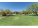 Green lawn and landscaping featuring covered structure, with desert vegetation, blue skies, and mountain view in the distance at 7606 E Globemallow Ln, Gold Canyon, AZ 85118