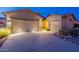 Well lit front exterior with a long driveway and three-car garage at 7606 E Globemallow Ln, Gold Canyon, AZ 85118