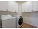 Laundry room with white cabinets, a top load washing machine, and front load dryer at 7606 E Globemallow Ln, Gold Canyon, AZ 85118