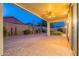 Covered outdoor patio with ceiling fan and brick flooring at twilight at 7606 E Globemallow Ln, Gold Canyon, AZ 85118