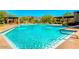 Community pool showcasing a crystal clear swimming area, surrounding chairs, and outdoor lounge space at 7606 E Globemallow Ln, Gold Canyon, AZ 85118