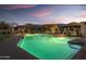Night shot of the community pool area and lounge space with sunset sky backdrop at 7606 E Globemallow Ln, Gold Canyon, AZ 85118