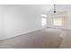 Bright, carpeted living room featuring tall windows and a ceiling fan at 7767 W Sierra Vista Dr, Glendale, AZ 85303
