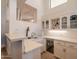 A stylish bar area features white cabinets, quartz countertops, wine rack, and a beverage fridge for seamless entertaining at 8502 E Santa Catalina Dr, Scottsdale, AZ 85255