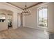 Elegant dining room featuring a modern chandelier, light wood floors, and large windows at 8502 E Santa Catalina Dr, Scottsdale, AZ 85255