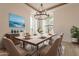 A brightly lit dining room with a large picture window, modern lighting and seating for six at 8502 E Santa Catalina Dr, Scottsdale, AZ 85255