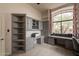 Custom home office with built-in desks, shelving, and natural light from large windows at 8502 E Santa Catalina Dr, Scottsdale, AZ 85255