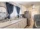 Well-lit laundry room with ample counter space, wallpaper accent, and modern appliances at 8502 E Santa Catalina Dr, Scottsdale, AZ 85255
