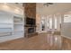 Cozy living room featuring a stone fireplace, built-in shelving, and hardwood floors at 8502 E Santa Catalina Dr, Scottsdale, AZ 85255