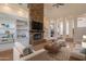 Open concept living room with a stacked stone fireplace, built-in shelving and hardwood floors at 8502 E Santa Catalina Dr, Scottsdale, AZ 85255