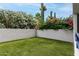 Backyard with lush synthetic lawn surrounded by lush vegetation and cacti at 902 W Glendale Ave # 102, Phoenix, AZ 85021