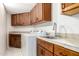 Functional laundry area with white appliances, wooden cabinets and tiled counters at 902 W Glendale Ave # 102, Phoenix, AZ 85021
