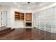 Living room with hardwood floors, a fireplace, built-in cabinets, and a sliding glass door with white shutters at 902 W Glendale Ave # 102, Phoenix, AZ 85021