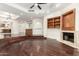Open-concept living room with hardwood floors, a fireplace, built-in cabinets, and stairs at 902 W Glendale Ave # 102, Phoenix, AZ 85021