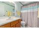 Bright bathroom featuring a vanity, toilet, mirror, and shower with colorful curtain at 922 S 80Th St, Mesa, AZ 85208