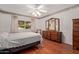 Cozy bedroom features hardwood floors, a ceiling fan, dresser, and a window providing natural light at 922 S 80Th St, Mesa, AZ 85208