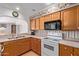 Well-lit kitchen features ample counter space, bright cabinetry, essential appliances, and charming wallpaper accents at 922 S 80Th St, Mesa, AZ 85208