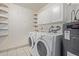 Functional laundry room with washer, dryer, storage cabinets, and tiled floor at 922 S 80Th St, Mesa, AZ 85208