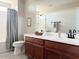 Spacious bathroom featuring dual sinks, a large mirror, and a shower-tub combination at 984 W Belmont Red Trl, San Tan Valley, AZ 85143