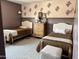 Cozy bedroom with two twin beds, soft carpet, floral stencils, and warm lighting for a relaxing ambiance at 984 W Belmont Red Trl, San Tan Valley, AZ 85143